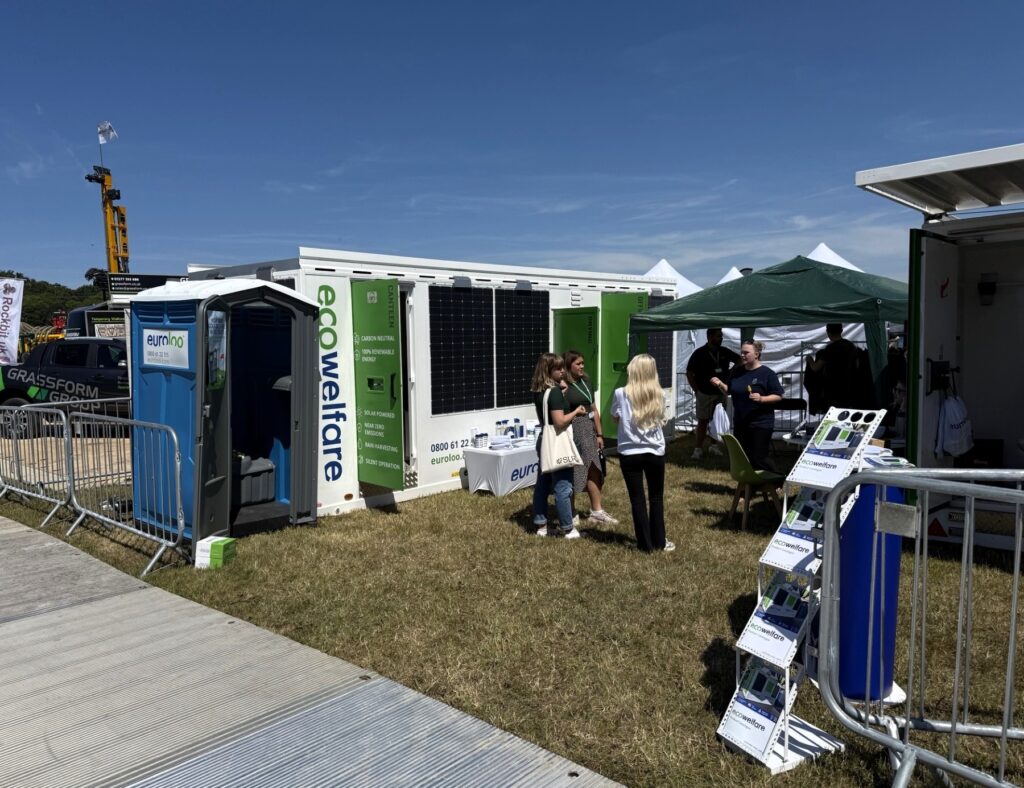 Solar-Powered Ecowelfare Stand At Geotechnica25 Showcasing 12Ft Welfare Unit And Solar Toilet With Visitors In Attendance.