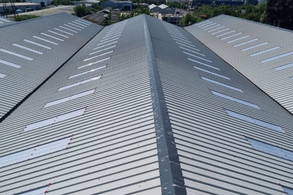 Commercial Roofing Contractors Working On Large Industrial Roof Refurbishment In England